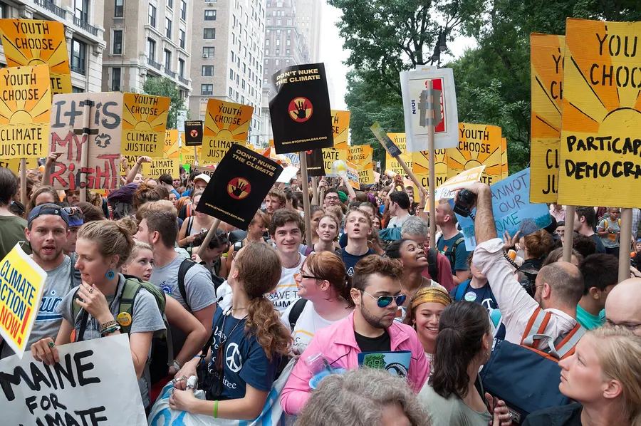 A large crowd of marchers carrying signs along a city street.
