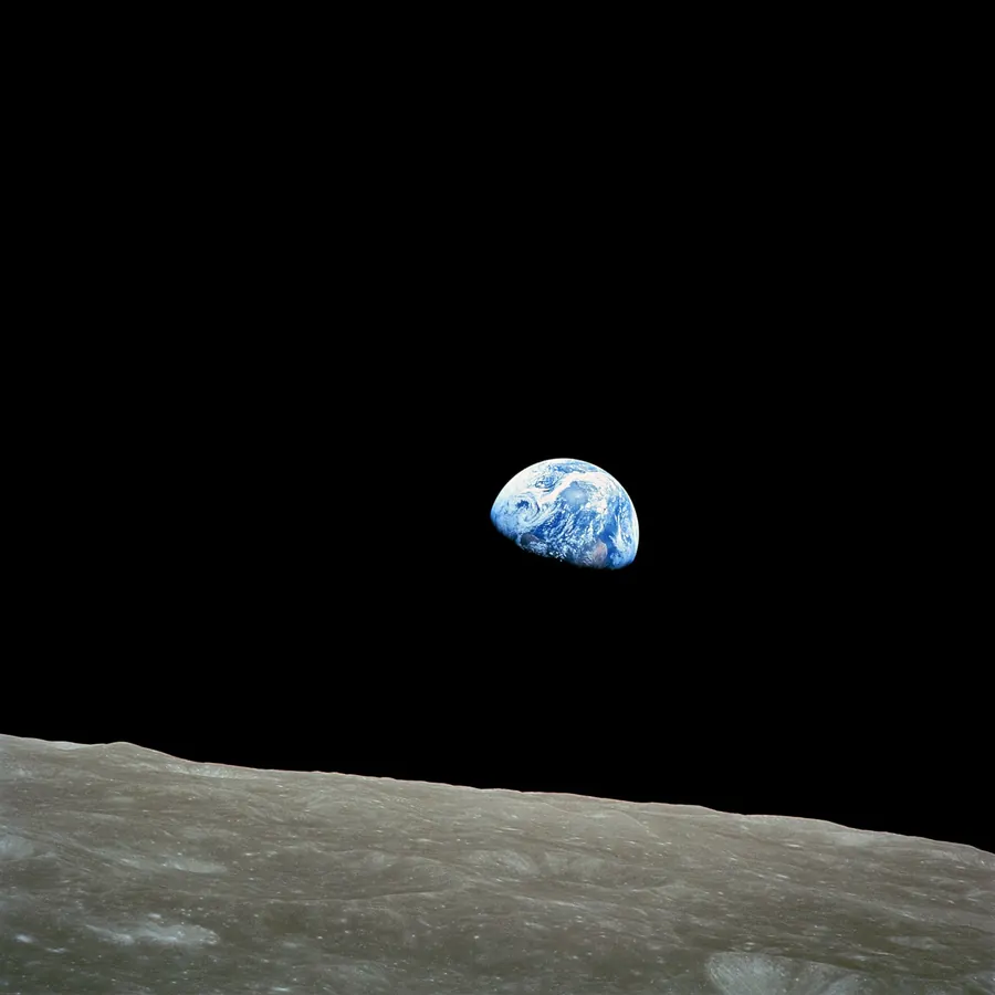 The blue Earth rising above the grey surface of the Moon.